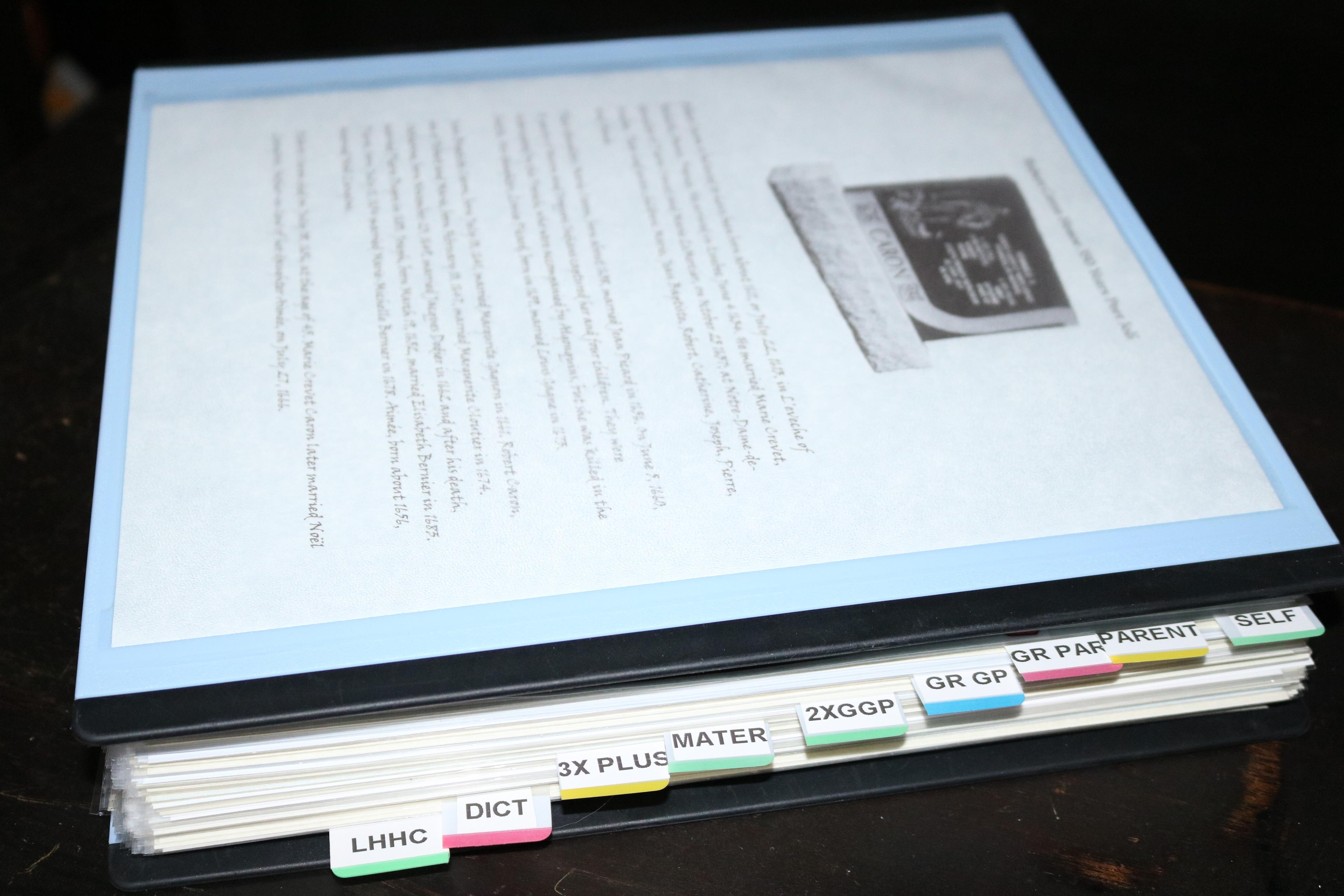 Genealogy research binder with generation tabs and a Caron cover page