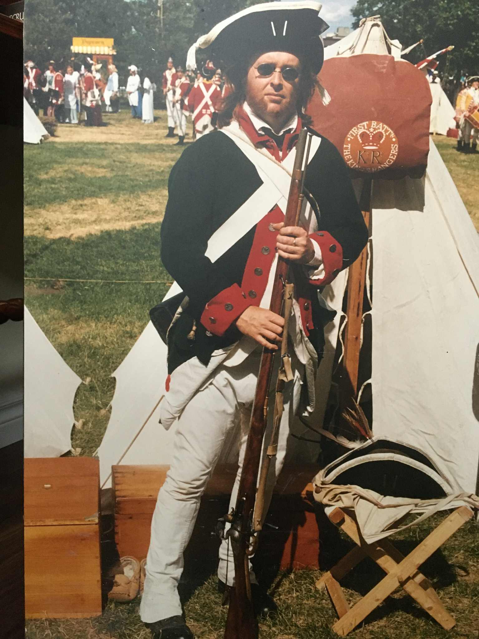 Wayne Franks in King’s Rangers uniform with musket, First Battalion banner behind a canvas tent
